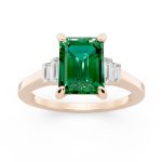 Bezel set three stone emerald engagement ring in rose gold, front view