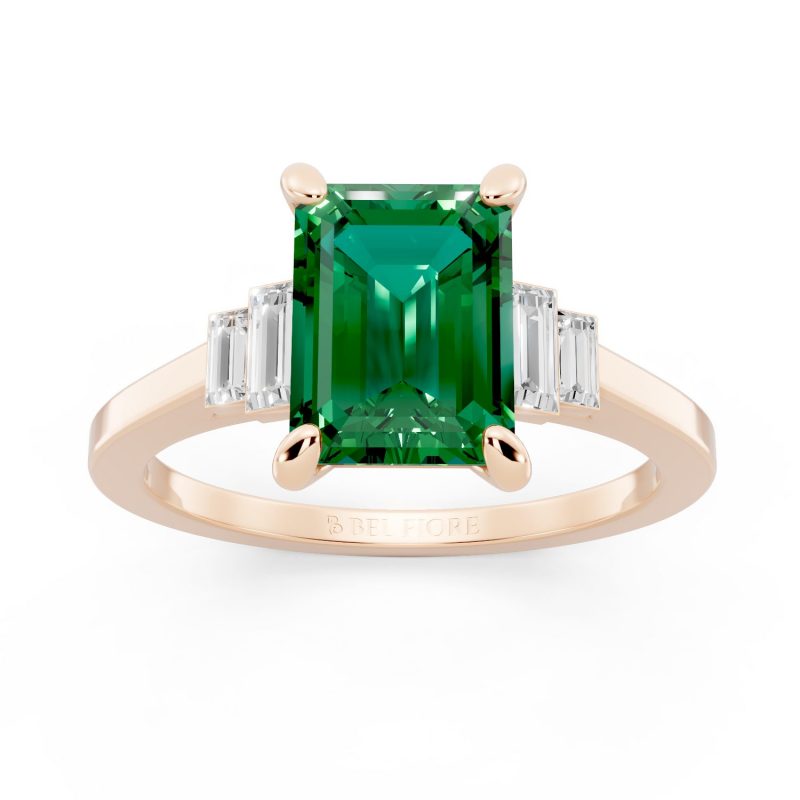 Bezel set three stone emerald engagement ring in rose gold, front view
